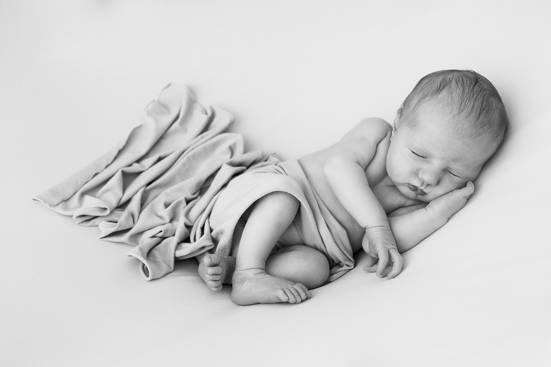 Photo de naissance artistique bébé endormi Posing